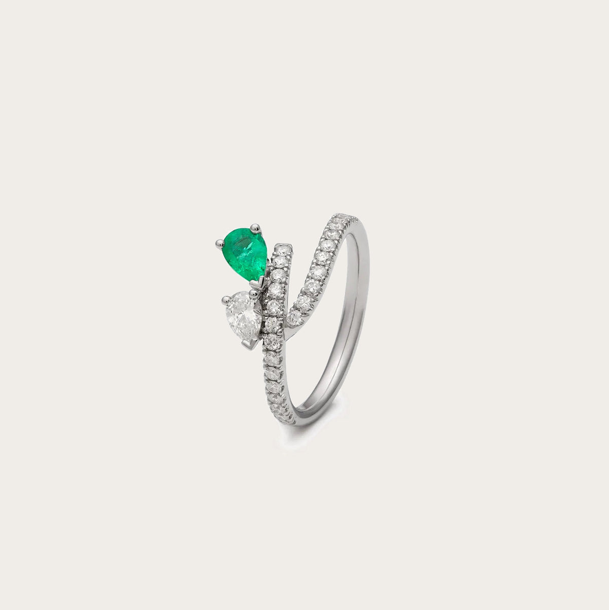 Anillo abierto de esmeralda en lágrima. Las bandas se separan en el frente y sitúan los centros a distinta altura.