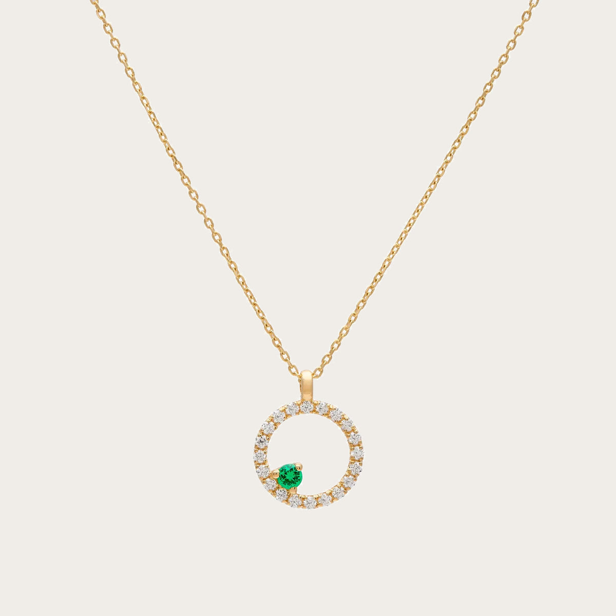 Colgante circular de brillantes y tsavorita. El motivo verde se sitúa en la parte inferior del aro luminoso.