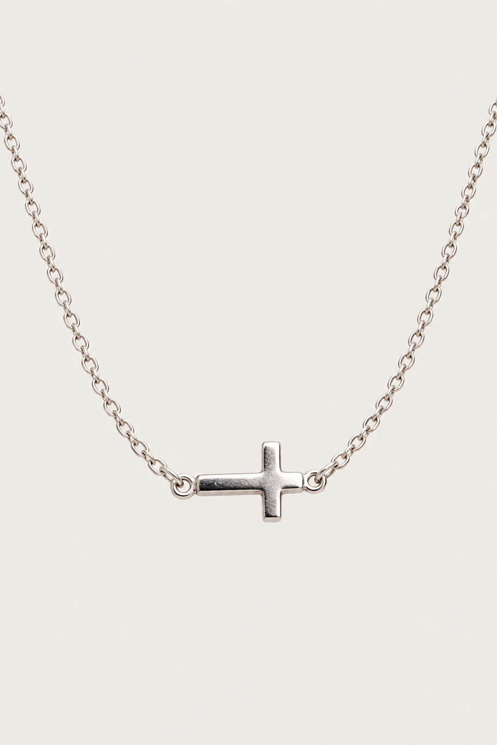 Brazalete cruz — pieza aislada sobre fondo gris