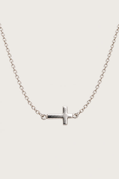 Brazalete cruz — pieza aislada sobre fondo gris