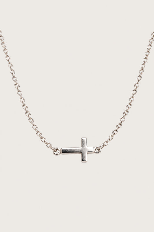 Brazalete cruz — pieza aislada sobre fondo gris