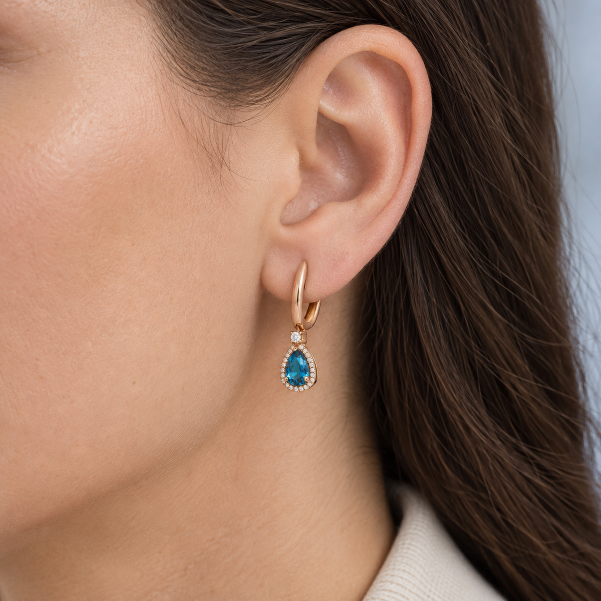 Pendientes de aro dorado y lágrima azul V-3239/P — primer plano de la joya puesta