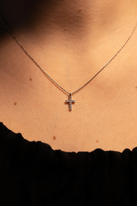 Colgante de cruz de diamantes en oro blanco con cadena fina, puesto en el cuello