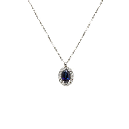 Colgante oval azul con halo. Las pequeñas piedras incoloras siguen el contorno de la piedra principal.