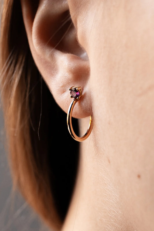 Pendiente de aro de oro de 18 k con piedra rosa en garras, puesto en la oreja