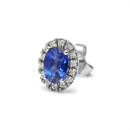 Pendientes de centro azul oval y halo. Las piedras incoloras del contorno se presentan en monturas visibles.