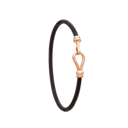 Pulsera de acero y oro con motivo abierto. El detalle central dibuja un contorno alargado con espacio interior.