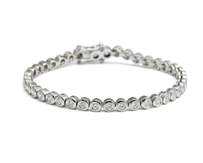 Pulsera rivière de centros redondos. Los bordes de tono plateado enmarcan cada piedra incolora.