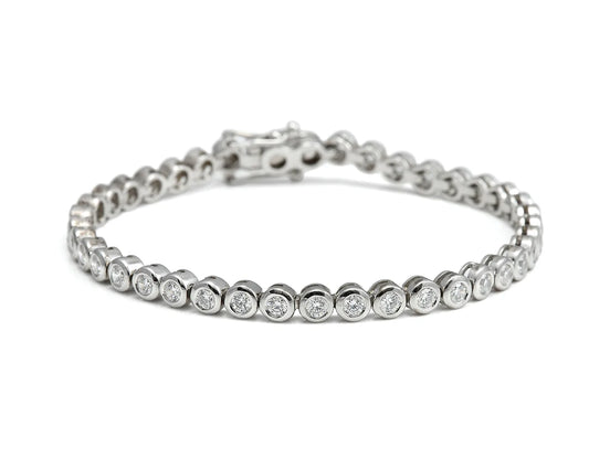 Pulsera rivière de centros redondos. Los bordes de tono plateado enmarcan cada piedra incolora.