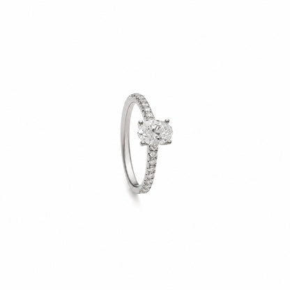 Anillo de diamante oval y brillantes. La montura de garras deja visible el contorno ovalado del centro.